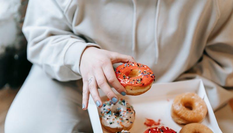 une jeune femme mange des beignets