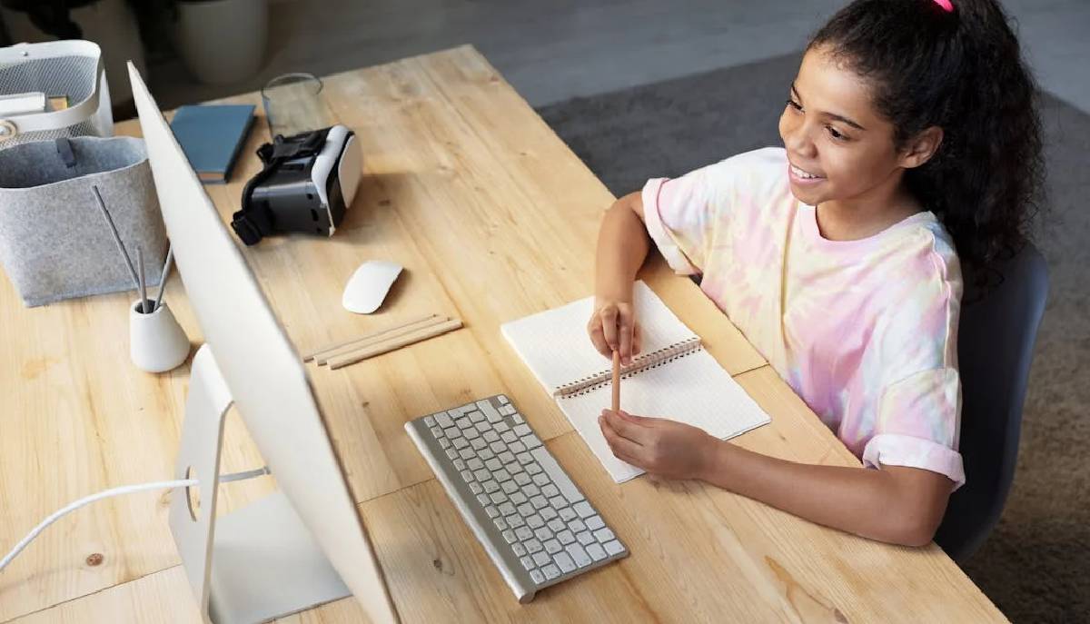 Étudiant assis au bureau en utilisant l'ordinateur